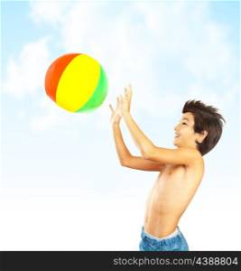 Happy boy with beach ball over blue sky, kid having fun outdoor, healthy child playing outside, cute teen enjoying sport and nature, summer holidays and vacation