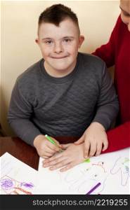 happy boy with down syndrome drawing