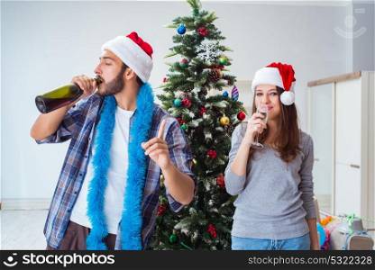 Happy boyfriend and girlfriend drinking champagne on christmas