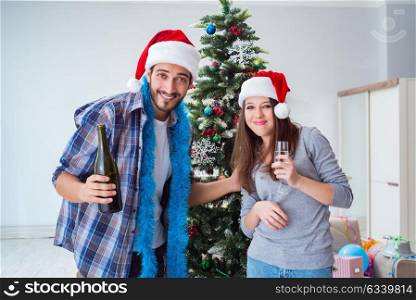 Happy boyfriend and girlfriend drinking champagne on christmas