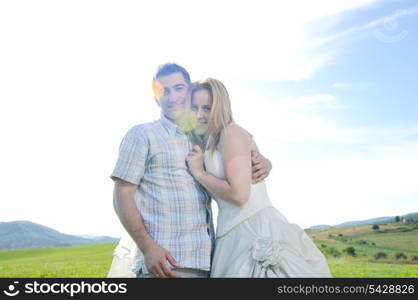 happy bride and groom walking and run on beautiful meadow outdoor at sunset