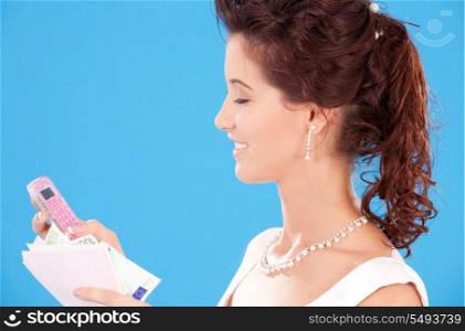 happy bride with calculator and money over blue