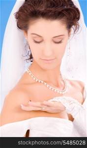 happy bride with her wedding ring over blue