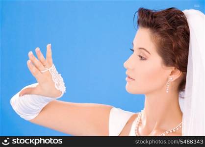 happy bride with her wedding ring over blue