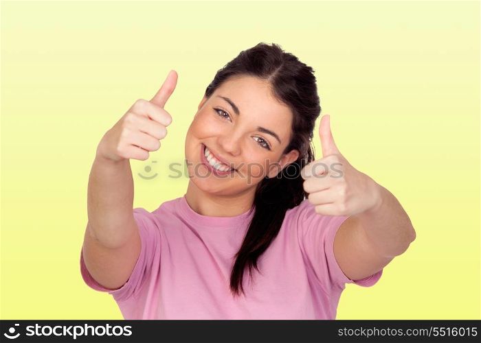 Happy brunette girl saying Ok isolated on yellow background