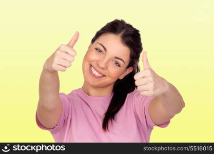 Happy brunette girl saying Ok isolated on yellow background