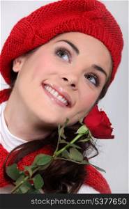Happy brunette holding a red rose