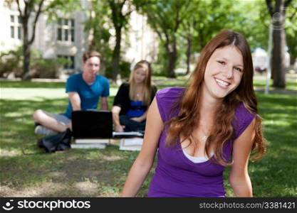 Happy brunette student smiling at the camera