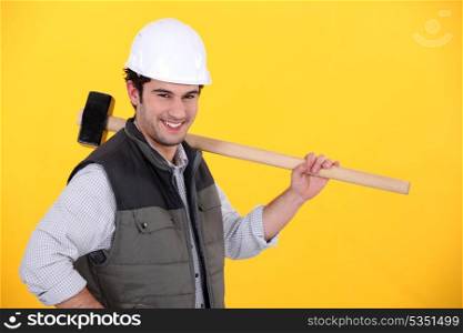 Happy builder carrying sledge-hammer
