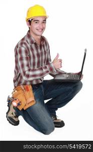 Happy builder with laptop giving the thumbs-up