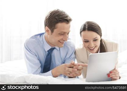 Happy business couple using digital tablet in hotel room
