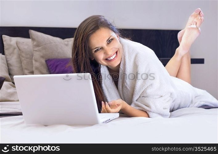 happy business lady on the bed with laptop