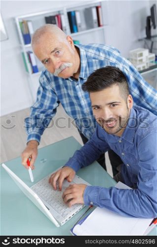 happy business partners or co-worker behind a desktop computer