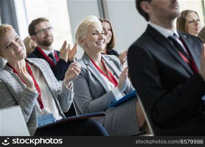 Happy business people applauding during seminar