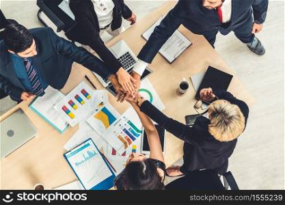 Happy business people celebrate teamwork success together with joy at office table shot from top view . Young businessman and businesswoman workers express cheerful victory showing unity and support .