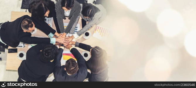 Happy business people celebrate teamwork success together with joy at office table shot from top view . Young businessman and businesswoman workers express cheerful victory in broaden view .. Happy business people celebrate teamwork success broaden view