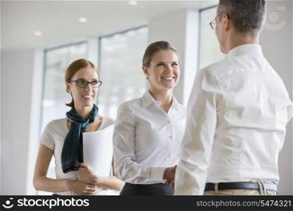 Happy business people shaking hands in office