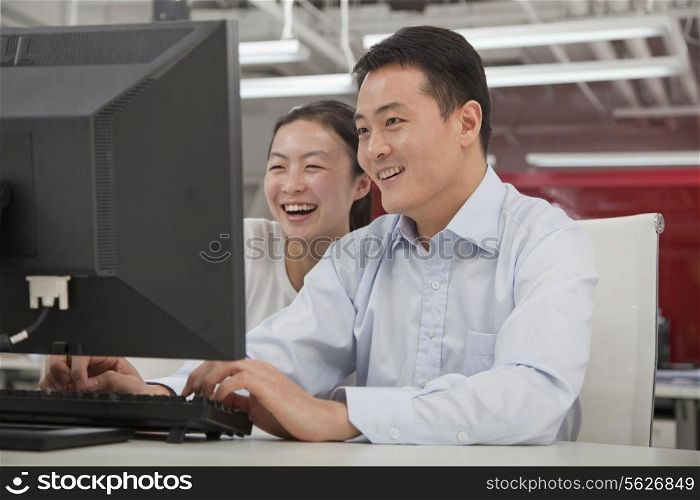 Happy business people working on their computer in the office