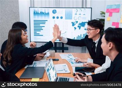Happy business team office worker making high five with each other and celebrate after successful meeting in office workplace, business agreement to promote harmony and strong teamwork concept.. Happy office worker making high five with each other in harmony workplace.