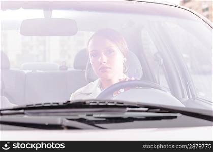 happy business woman in a car is looking at camera