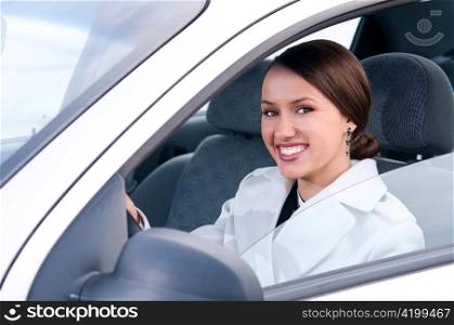 happy business woman in a car is looking at camera
