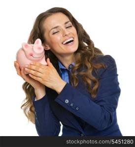 Happy business woman listening whats inside piggy bank