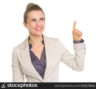 Happy business woman pointing up on copy space