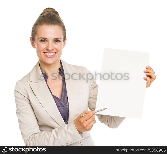 Happy business woman pointing with pen on blank paper sheet