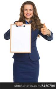Happy business woman showing blank clipboard and thumbs up