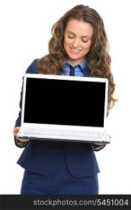 Happy business woman showing laptop blank screen