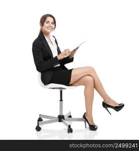 Happy business woman sitting on chair working with a tablet, isolated over white background