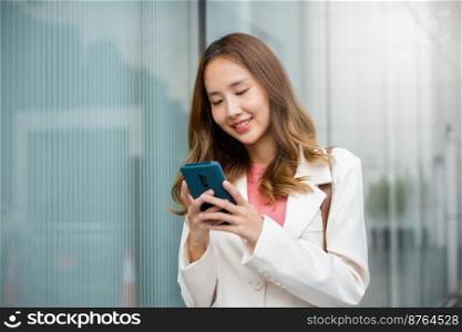 Happy business woman smiling using mobile phone outdoor walking on city street urban, Asian businesswoman texting smartphone commuting work she walking near her office building in morning