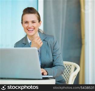 Happy business woman working on laptop