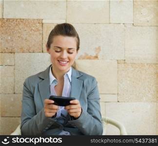 Happy business woman writing text message on cell pone