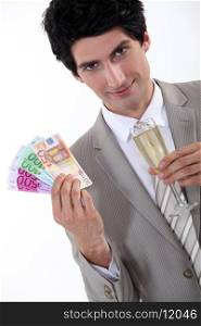 happy businessman holding money in cash and a glass of champagne