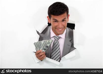 Happy businessman holding wedge of bank notes