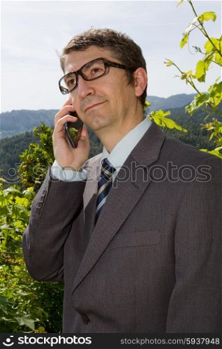 Happy businessman outdoor talking through mobile phone