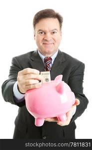 Happy businessman saving a hundred dollar bill in a piggy bank. Isolated on white.