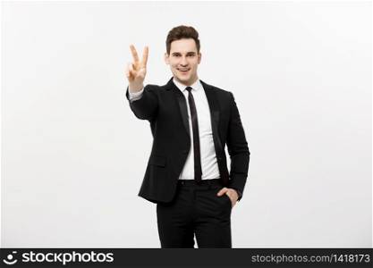Happy businessman showing two fingers or victory gesture, against grey background. Success in business, job and education concept. Blank copyspace area for advertisiment, slogan or text.. Happy businessman showing two fingers or victory gesture, against grey background. Success in business, job and education concept. Blank copyspace area for advertisiment, slogan or text