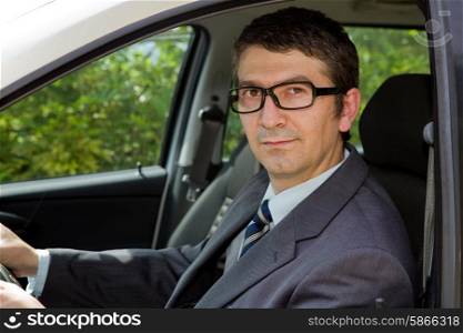 Happy businessman sitting in drivers seat in his car