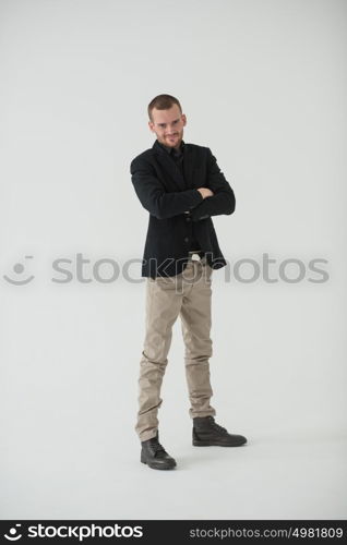 Happy businessman standing with arms folded on white background, natural light