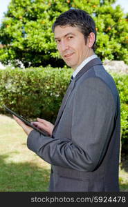 happy businessman with digital tablet, outdoors