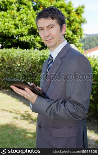 happy businessman with digital tablet, outdoors