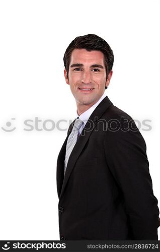 Happy businessman with his hands behind his back