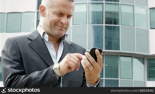 Happy businessman with mobile telephone, visiting web site and browsing the internet