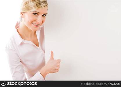Happy businesswoman behind blank advertising banner thumbs up