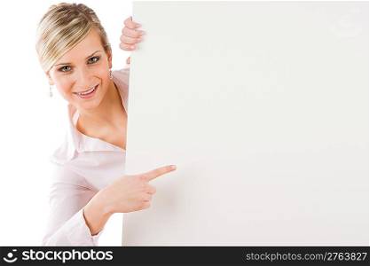 Happy businesswoman pointing aside at blank advertising banner on white