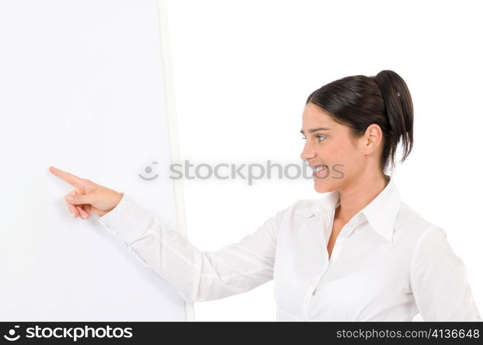 Happy businesswoman pointing at empty flip chart on white