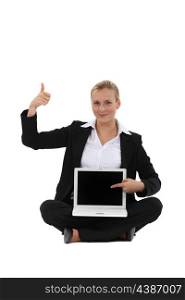 Happy businesswoman showing laptop