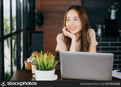 Happy businesswoman smiling sitting alone at cafe desk with laptop computer she looking out of window, portrait of beautiful woman smile in coffee shop in morning, freelance lifestyle